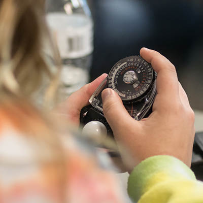 A close-up of student holding a measuring tool.