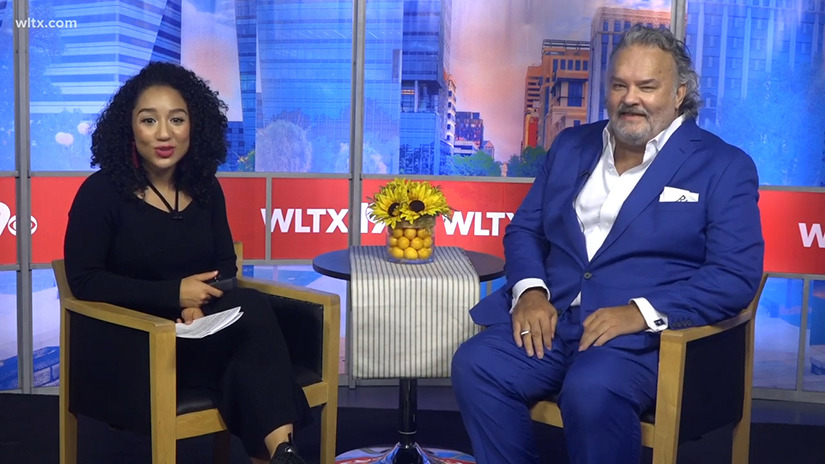 Whitney Sullivan from WLTX and research professor Rich Harrill are seated on a television studio set.