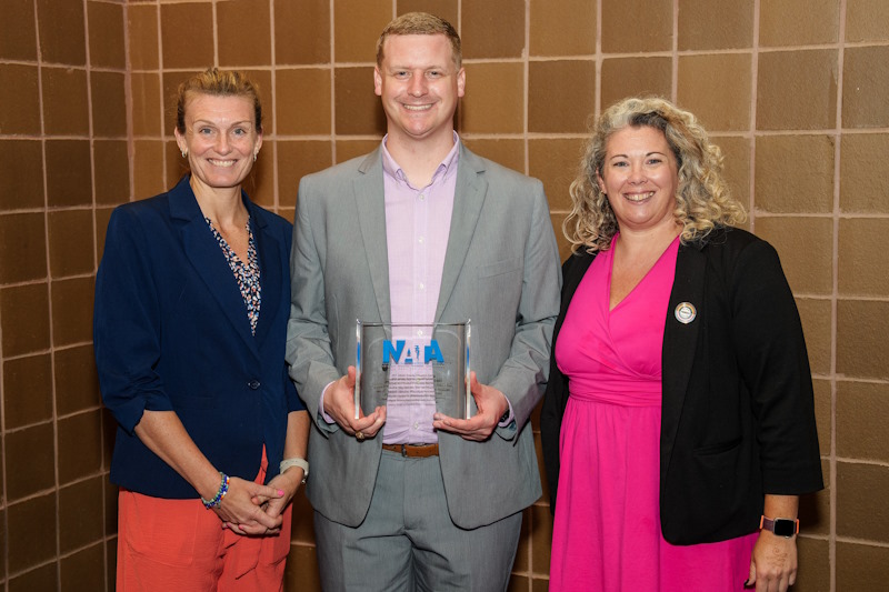 Zachary Winkelmann (center) accepts the Athletic Training Education Journal award on behalf of his co-authors.