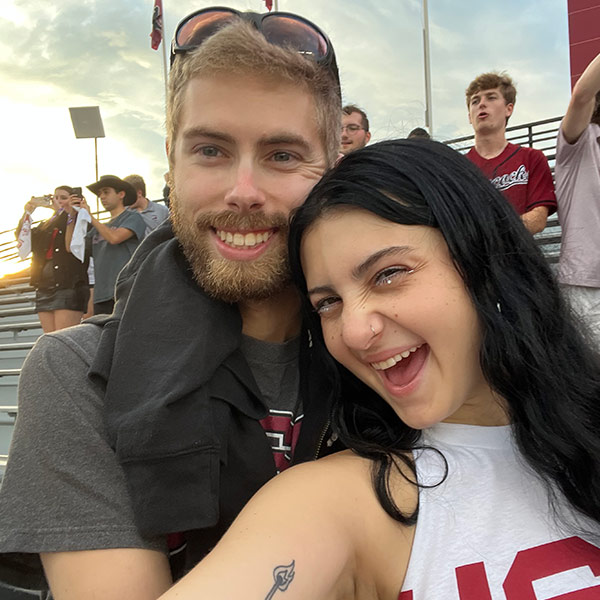 Man and woman smiling in the stands at the football stadium